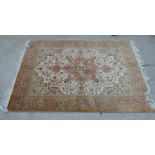 A Tabriz part silk rug, decorated with flora and stylised designs, on a beige coloured ground  58" x