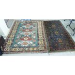 Two similar woollen rugs, variously decorated with floral and other designs, one on a dark blue