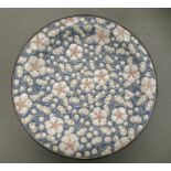 An early 20thC satsuma earthenware dish, decorated with moulded prunus blossom, on a pale blue