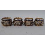 A set of four late Victorian Royal Doulton stoneware salt cellars of footed, ogee form, decorated