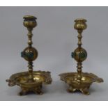 A pair of early 20thC brass candlesticks, each comprising a vase shape socket, over a ring turned