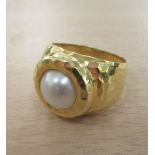 A 14ct gold ring, set with a half-cut simulated pearl