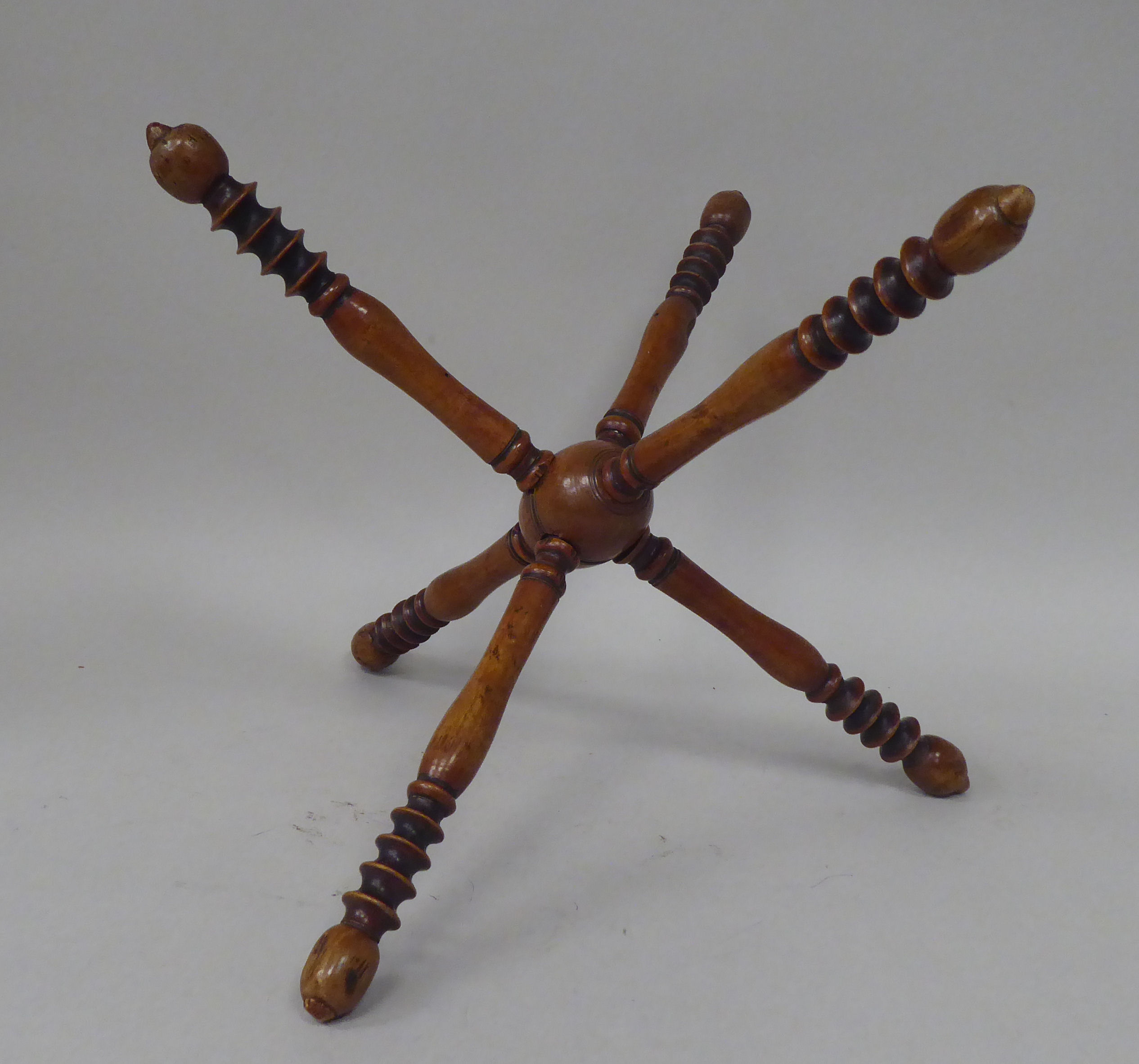 A late 19thC fruitwood wool winder, comprising six ring turned spindles, threaded to the central