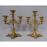 A pair of late 19thC cast gilt metal table candelabra, each comprising three sockets and twin