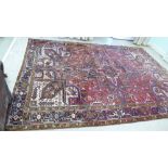 A Persian carpet, decorated with repeating geometric designs, on a multi-coloured ground  112" x