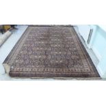 An English made, Persian inspired carpet, decorated with repeating motifs, bordered by stylised