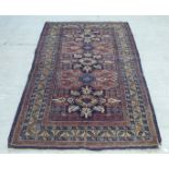 A Caucasian rug, decorated with three central medallions, bordered by stylised designs, on a multi-