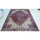 A Persian carpet, decorated with repeating stylised designs, on a multi-coloured ground  94" x 122"
