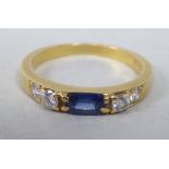 An 18ct gold five stone ring, set with a rectangular sapphire and diamonds