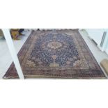 A Persian carpet, decorated with a central starburst motif, bordered by floral and foliage
