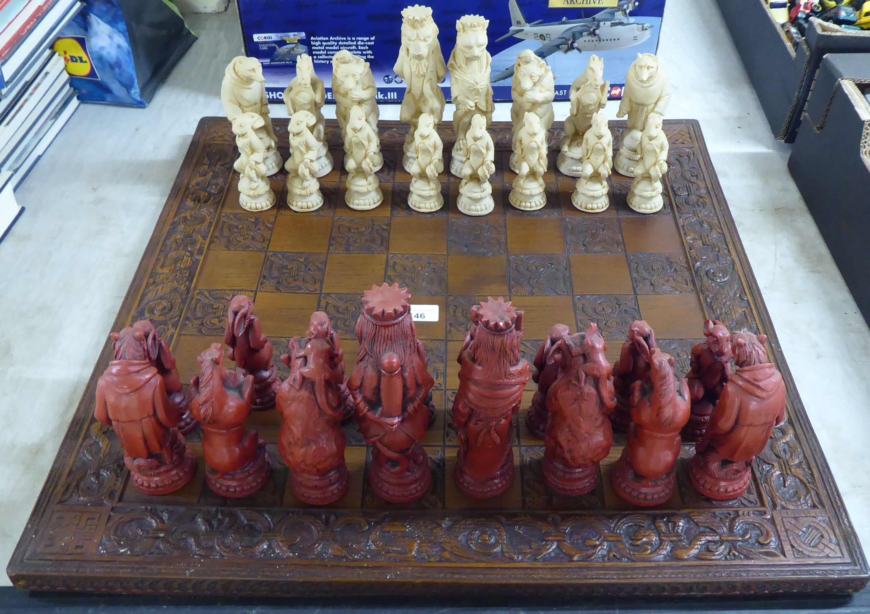 A novelty resin chess set, the board 23.5"sq