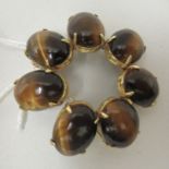A 14ct gold brooch, set with seven cabochon tigers eye stones