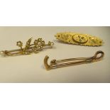 Three late Victorian scarf pins, viz. a 15ct gold riding crop; and two yellow metal examples