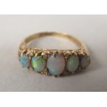 An 18ct gold opal and diamond ring, in a scrolled setting