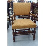 A 20thC Cromwellian style oak framed dining chair with an upholstered back and seat, raised on
