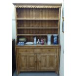 A 20thC reconstituted pine, one piece dresser with three open shelves, over two drawers and two