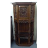 A late 19th/early 20thC Continental light oak credence style cupboard with heavily carved