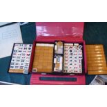 A Mah-jong set with bamboo effect resin tiles, in a travel case