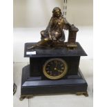 A late Victorian black slate cased mantel clock, surmounted by a gilt metal figure, a scholar,