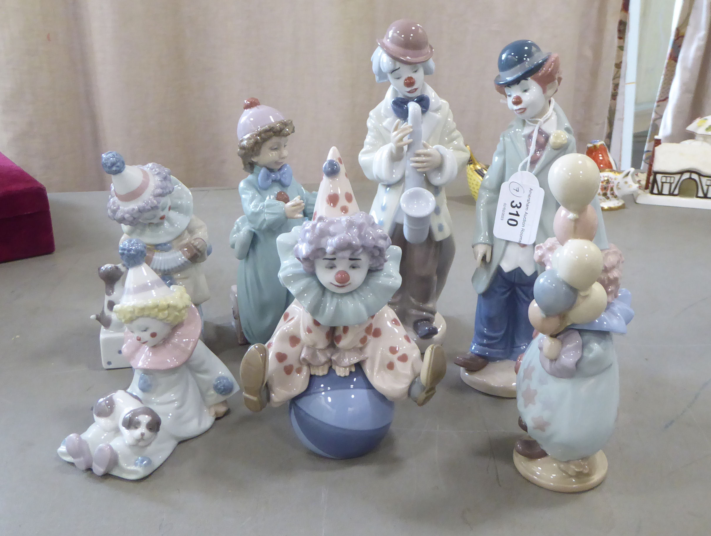 Seven Lladro porcelain clown themed figures: to include one playing a saxaphone  7"h