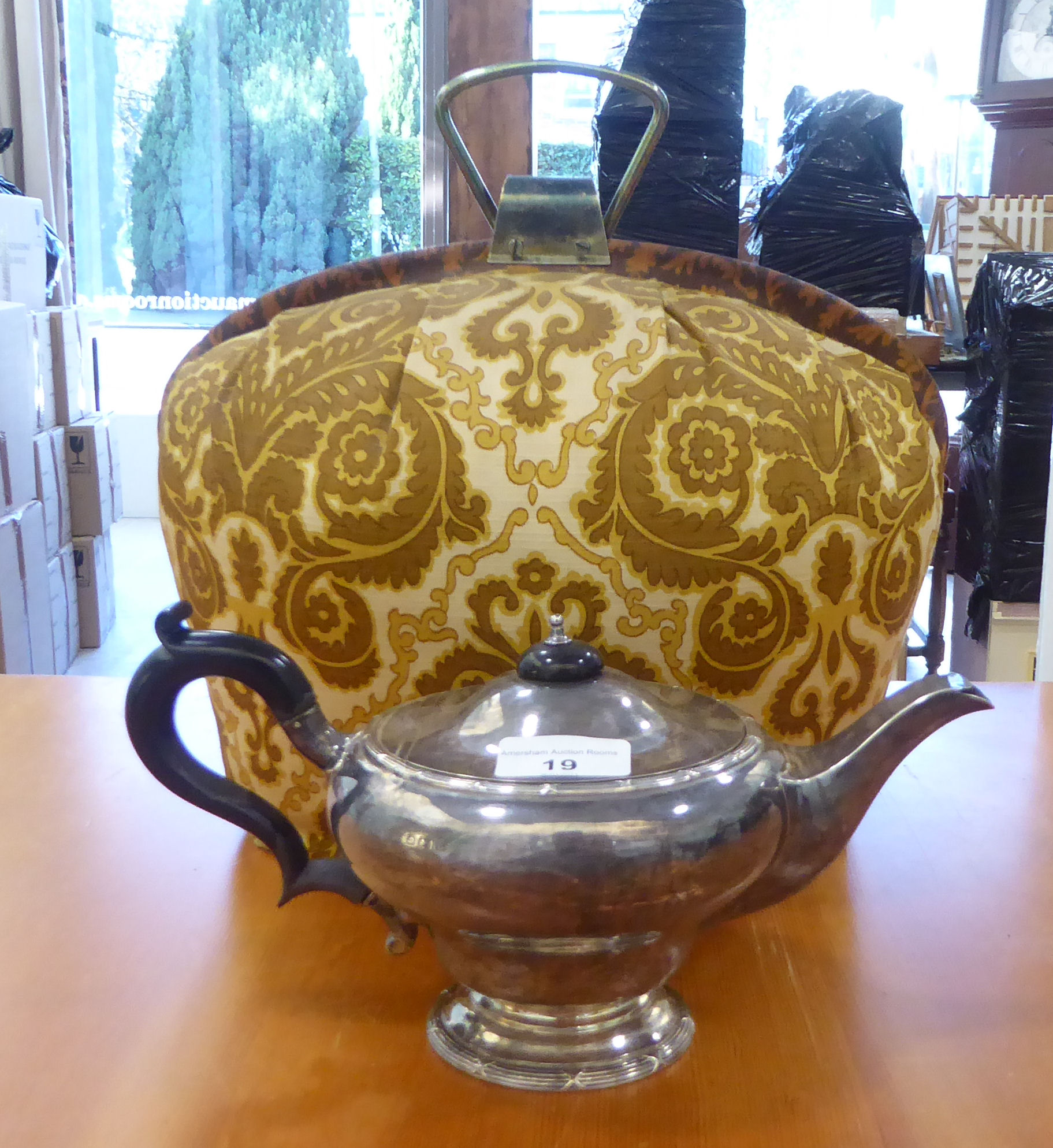 A George V silver teapot of bulbous form on a pedestal foot  Birmingham 1912 with a fabric tea