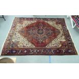 A Persian carpet, decorated with repeating stylised designs, on a multi-coloured ground  94" x 122"