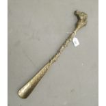 A mid 20thC cast brass shoe horn with an equestrian themed handles  20"L overall