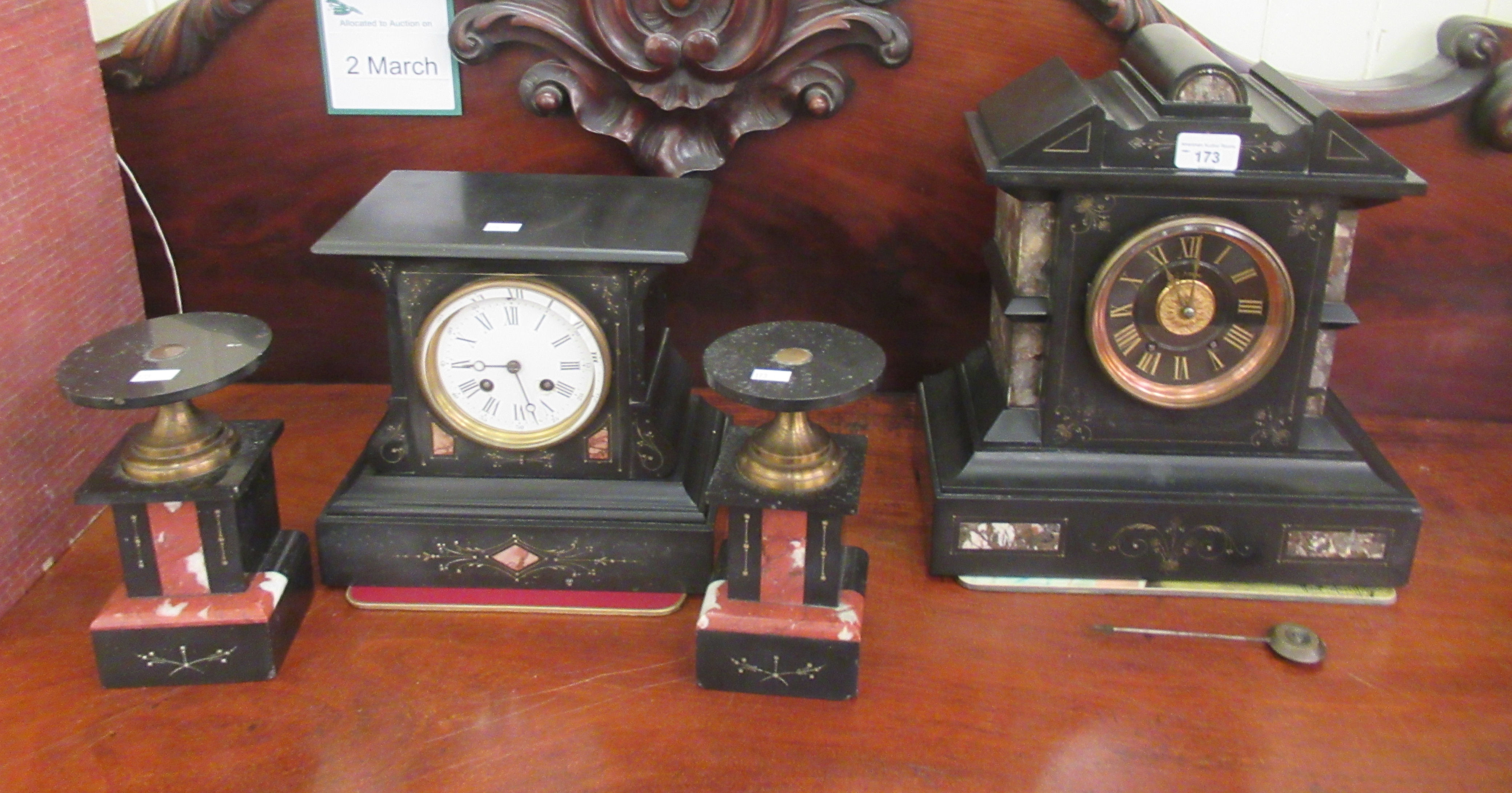 Two similar late Victorian black slate cased mantel clocks; each with an 8 day movement, faced by