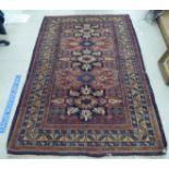 A Caucasian rug, decorated with three central medallions, bordered by stylised designs, on a multi-