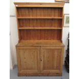 A late 19th/early 20thC pine dresser, the superstructure with two open shelves, over two panelled