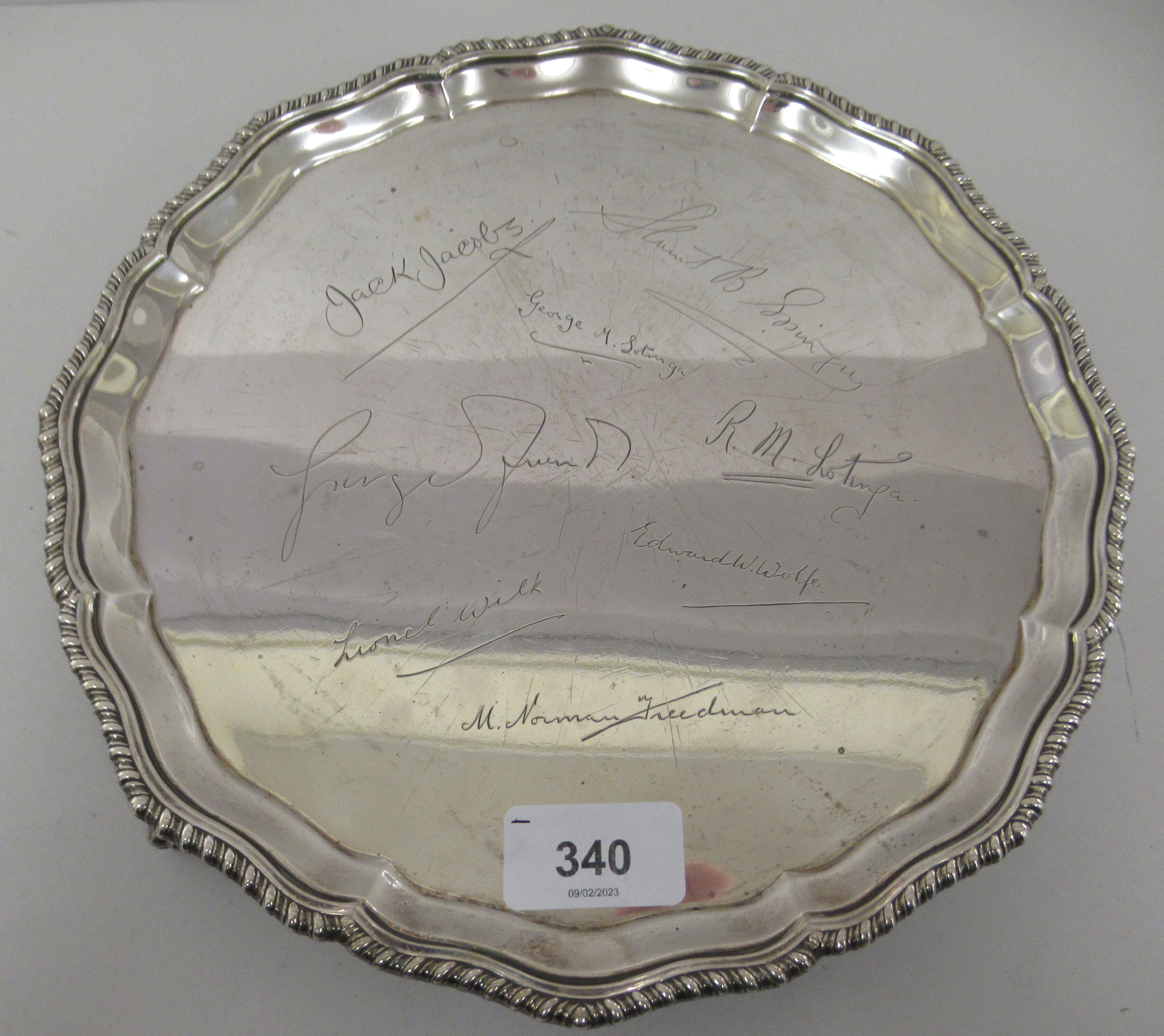 A Georgian style silver salver with a raised piecrust and gadrooned border, elevated on talon and