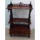A reproduction of a Victorian mahogany, three tier what-not with a fret carved gallery and single