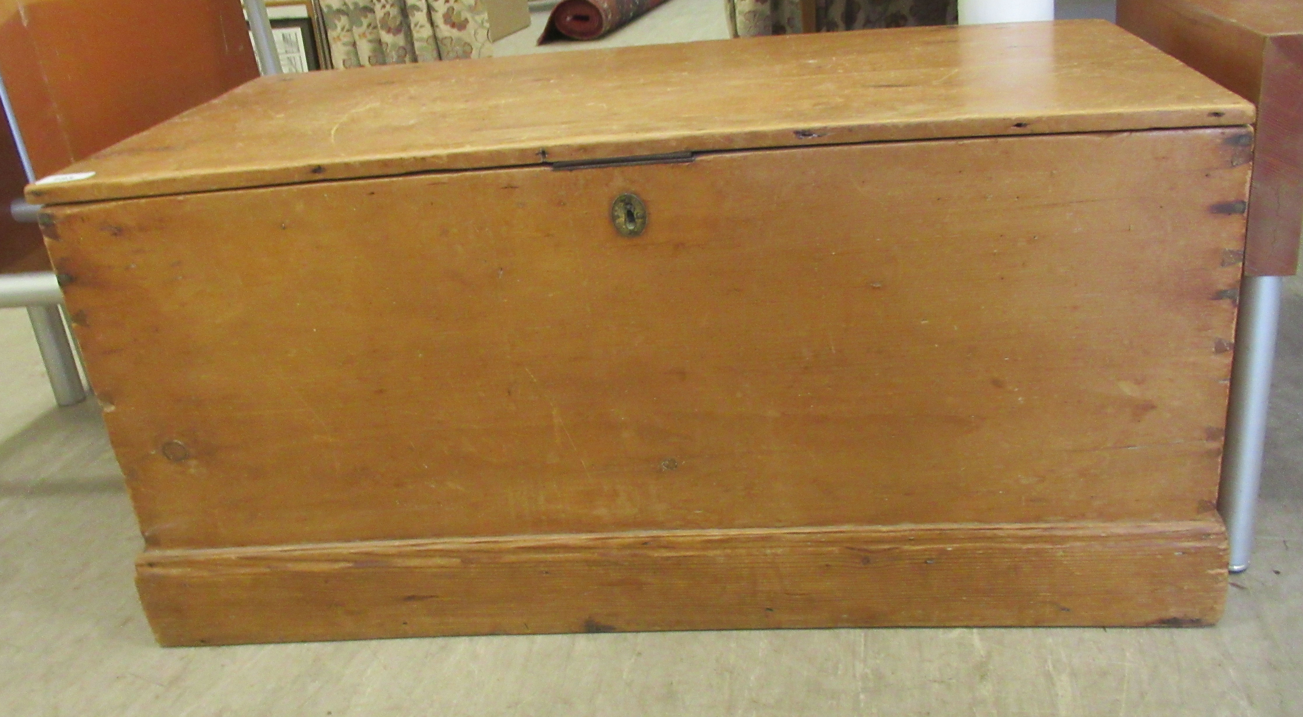 A late 19thC pine trunk with straight sides and a hinged lid, on a plinth  17"h  36"w