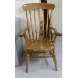 A modern beech framed armchair, the lath back over horseshoe design arms, over a solid seat,