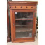 An early/mid 20thC oak corner cabinet with a glazed door, enclosing two shelves, on a plinth  33"