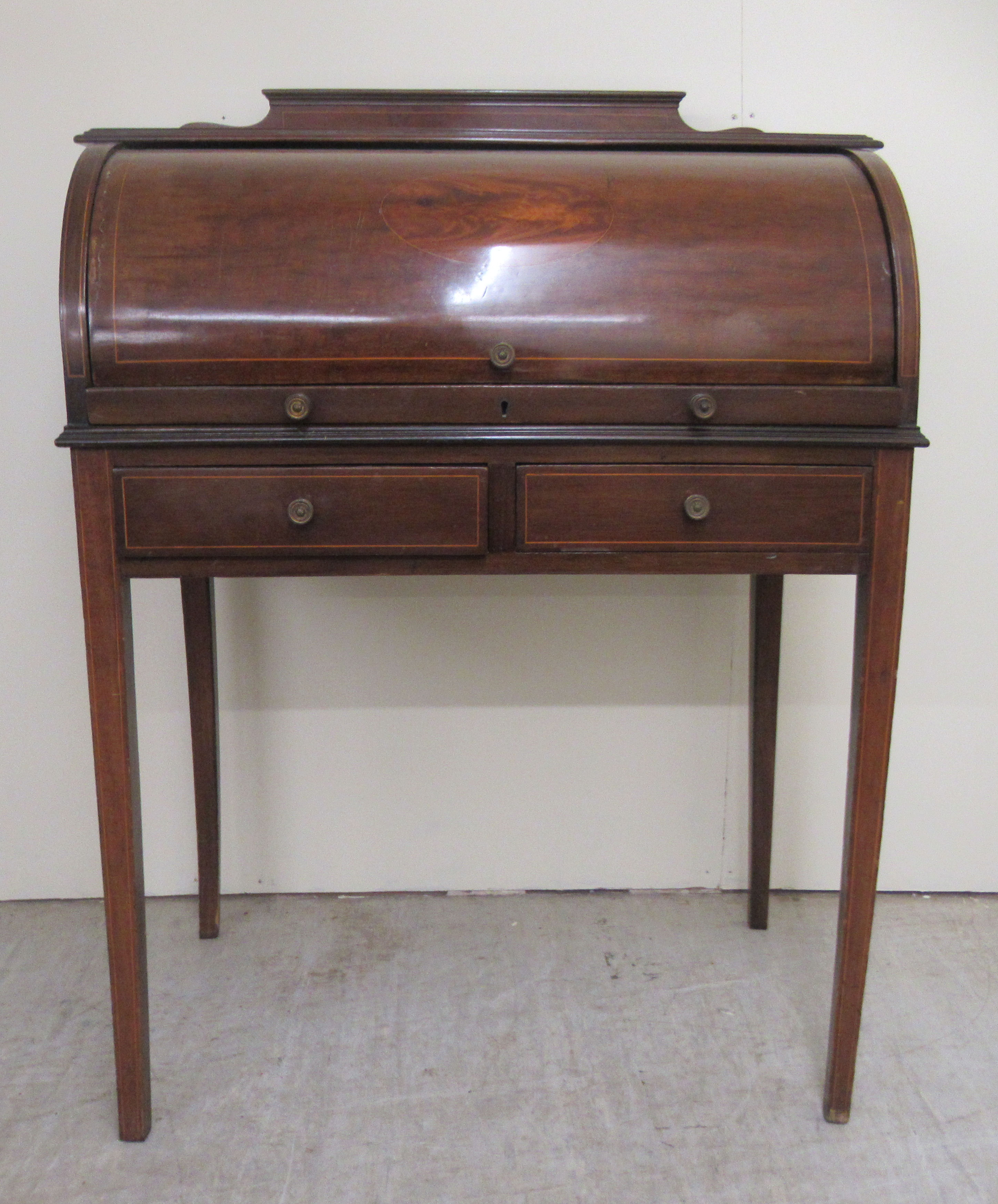 An Edwardian lady's satinwood inlaid mahogany cylinder front desk with a fitted interior, over two