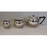 A late Victorian three piece silver tea set of oval, demi-reeded and stop-fluted design with