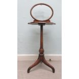 An early 20thC figured walnut veneered vanity table, surmounted by an oval, glazed frame, the top