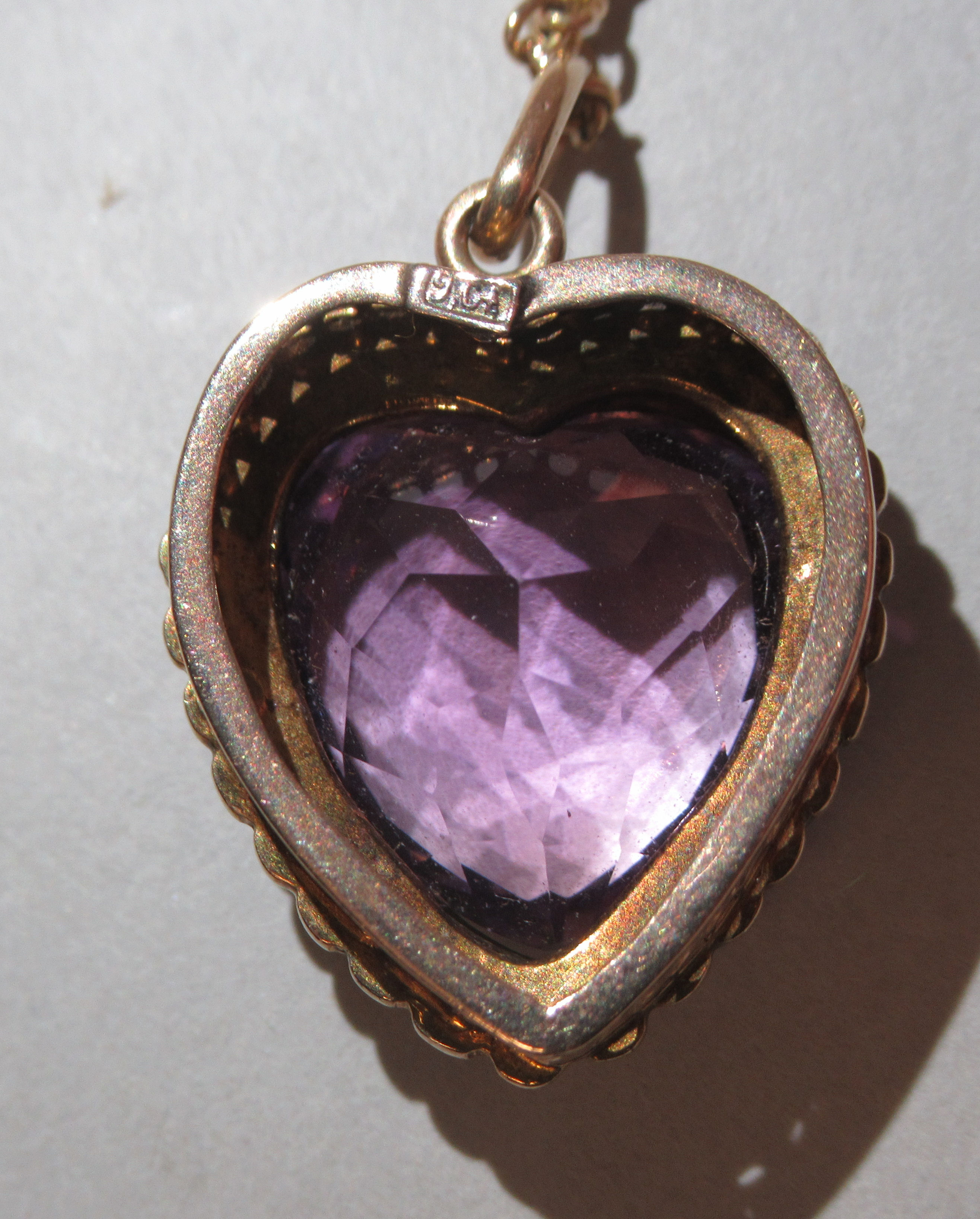 A 9ct gold heart shaped pendant, set with seed pearls around an amethyst coloured stone, on a fine - Image 5 of 5