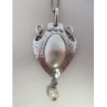 An Art Nouveau spot-hammered silver heart shape pendant, stamped VBO 950, on a fine white metal