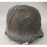 A German World War II paratroopers steel helmet with a hide liner and chin strap, mounted with