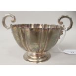 A silver sugar basin of reeded form with opposing scrolled handles, on a pedestal foot  PHA