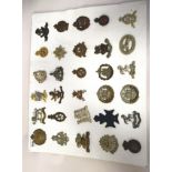 Approx. thirty military regimental cap badges and other insignia, some copies: to include 10th Royal