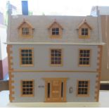 A 19thC style two storey dolls house with attic rooms and a hinged front  33"h  31"w