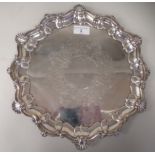 An Edwardian silver salver with a raised, shell cast and scrolled, piecrust border and engraved