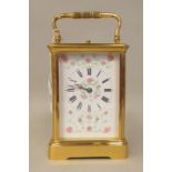 A modern lacquered brass cased carriage timepiece with bevelled glass panels and a folding top