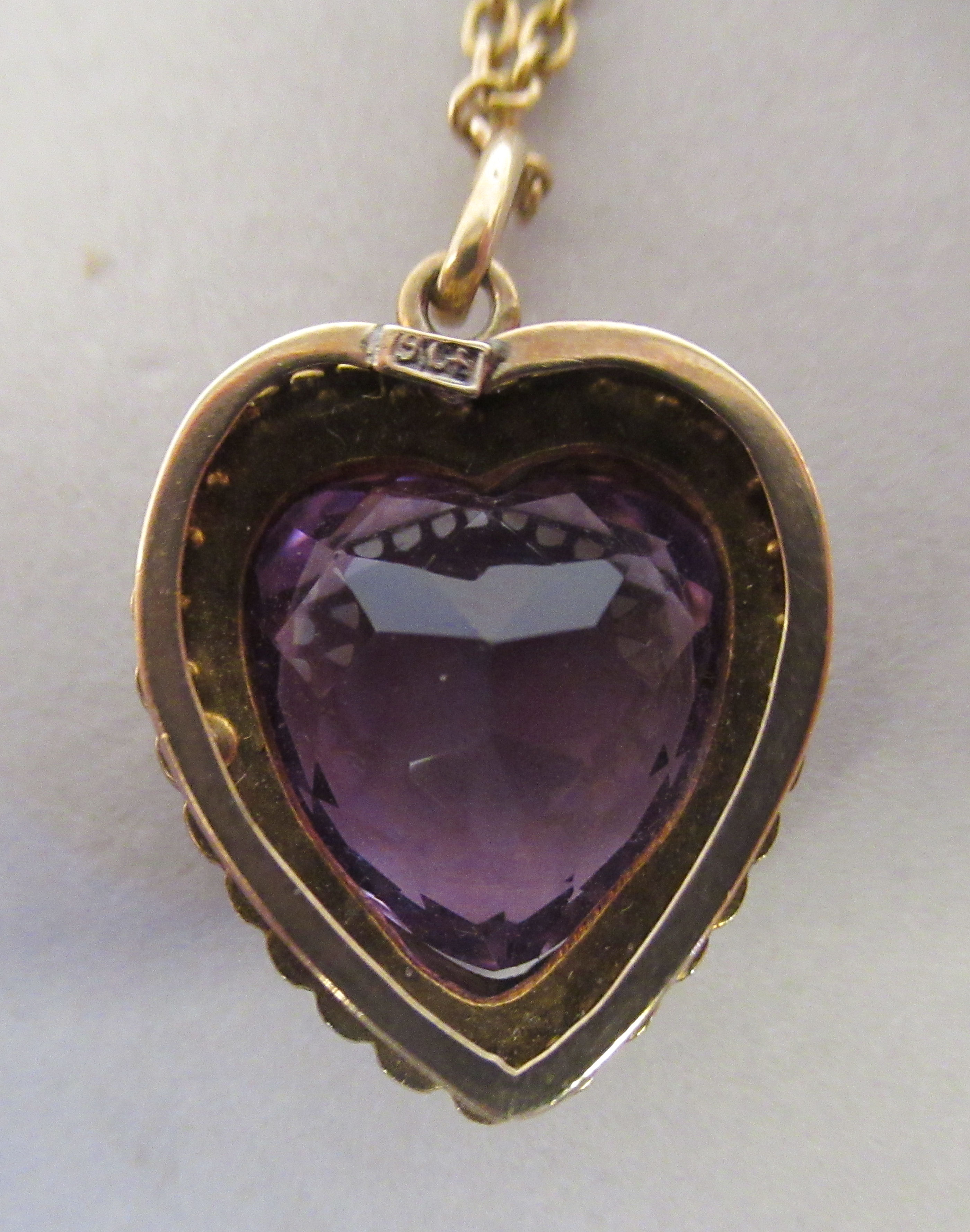 A 9ct gold heart shaped pendant, set with seed pearls around an amethyst coloured stone, on a fine - Image 4 of 5