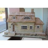 An Encharnted Castles two storey faux thatched dolls house with a sliding front access  24"h  33"w