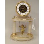 An early 20thC French alabaster and lacquered brass cased mantel timepiece of drum design, on twin