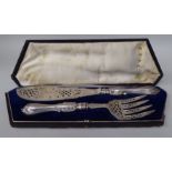 A pair of Victorian style silver fish servers with decoratively cast, pierced and chased ornament,